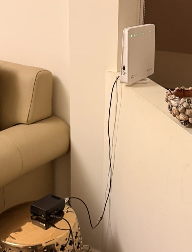 Haseeb's lounge: the modem on the ledge, and his Shield on the brass side table below it with its status light on.