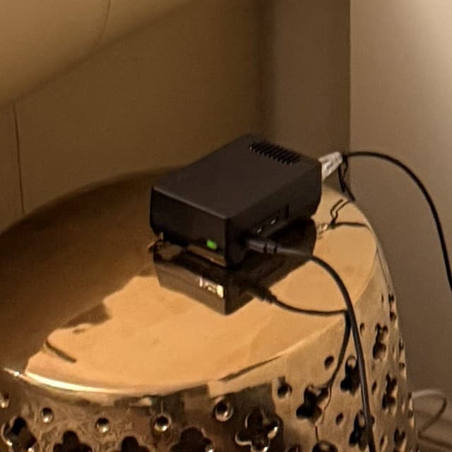 Haseeb's Shield on the brass side table in his lounge, green status light on.